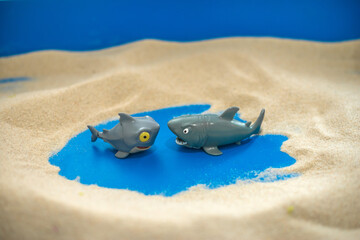 The concept of psychology. Sand therapy. Figures
of two sharks on the sand in a blue sandbox.
Psychology. Therapy. POST-traumatic
stress. Confrontation. Aggression.