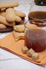 Bicchiere con tè per la colazione e piatto con biscotti