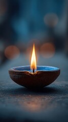 Clay oil lamp with glowing flame, spiritual ambiance in low light, soft bokeh background, traditional diya candle for meditation or festive decor

