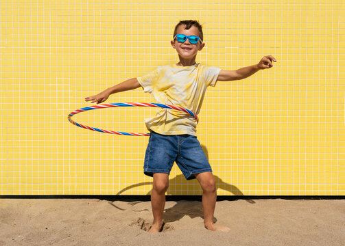 Happy and cool chinese young boy having fun at the beach during summertime - Powered by Adobe