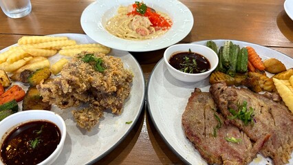 Pork steak and spaghetti cream sauce on the table, in lunch time.