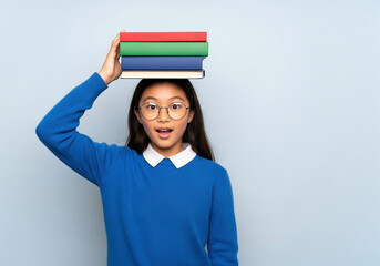 Obraz premium A preteen girl, positioned slightly off-center to the left side of the image, is holding a stack of books balanced on her head