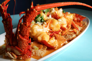 Australian Lobster with Savory Sauce on a Bed of Crispy Noodles in long dish closeup view of Chinese cuisine
