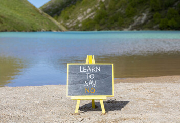 Learn to say no symbol. Concept words phrase Learn to say no on beautiful black blackboard. Beautiful mountain lake background. Business psychological Learn to say no concept. Copy space.