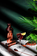 Red alcoholic cocktail drink with whiskey, french brandy, juice, grenadine and lime slice