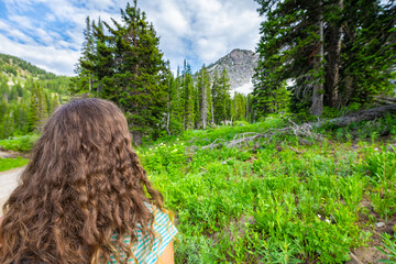 Albion Basin, Utah summer with woman back looking at landscape view on meadows trail to Cecret lake in Wasatch mountains