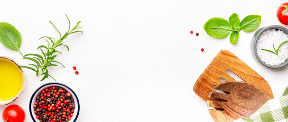 Food and cooking background, spices herbs, kitchen utensils, top view. Rose and black pepper, fresh rosemary, basil, tomatoes, olive oil and sea salt on white table