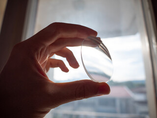 round glass lenses, eyewear technology, hand holding eyeglasses lenses