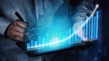 A business professional holds a tablet displaying dynamic financial data with an augmented reality...