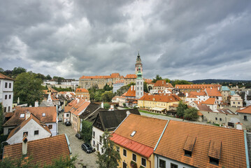 Obraz premium Český Krumlov, Czech Republic: Panoramic view of the historic town, castle, and Vltava River under a cloudy sky.