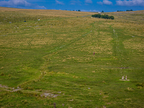 Aerial view of Bronze Age stone rows and settlement remains at Merrivale, Dartmoor, surrounded by grassy moorland and footpaths
