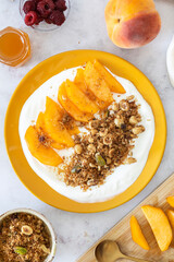 Healthy Breakfast Bowl with Greek Yogurt, Peach Slices, and Homemade Keto Granola