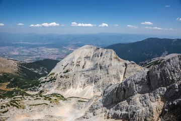 Mt. Tsarna Mogila and Tsernomogilski chal, a beautiful valley in Pirin highlands, and Bansko town behind it, in summer. View from Koncheto.