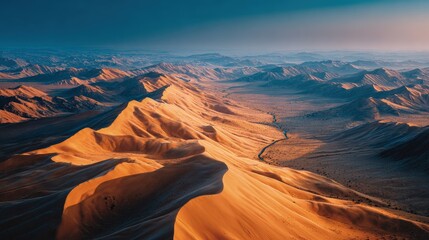 Fototapeta premium Drone shot overlooking a vast desert with rolling dunes scenic landscape under a deep blue twilight sky