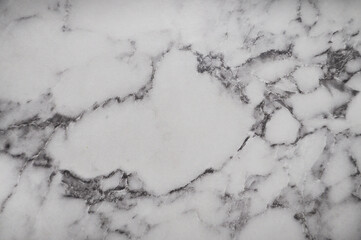 Elegant white marble texture with natural black veining. High-resolution close-up ideal for backgrounds, product mockups, or design elements. Classic and timeless stone surface.
