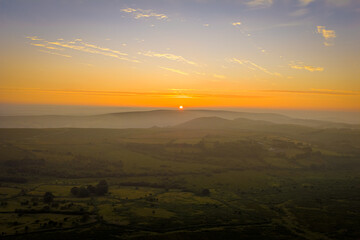 Family hiking on Dartmoor tors at sunset, silhouetted against dramatic skies in scenic moorland landscape
