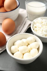 Different dairy products and eggs on grey wooden table, closeup