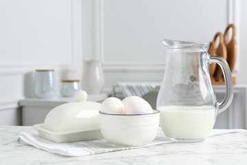 Different dairy products and eggs on white marble table indoors. Space for text