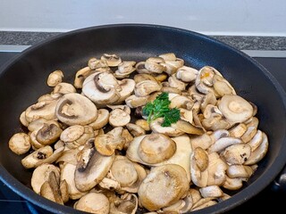 Geschnittne Pilze in der Pfanne anbraten - champignon
