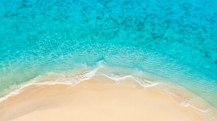 Tranquil aerial beach with gorgeous waves and soft sandy shore, tropical sea lagoon and island coastline under sunny sky. Beautiful nature landscape, artistic summer scenery, perfect travel wallpaper