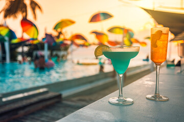 Relaxing poolside scene with two cocktails at sunset, warm golden light and blurred summer resort background. Luxury vacation atmosphere with chill vibes, happy hour, pool party, tropical travel mood