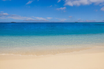 Beautiful tranquil sunny beach with soft sand, calm sea, and clear blue sky peaceful Mediterranean coastline perfect for beauty summer vacation, tourism, nature scenery and travel background wallpaper