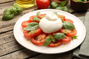 Tasty salad Caprese served with pesto sauce on wooden table, closeup