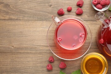 Aromatic raspberry tea, berries and honey on wooden table, flat lay. Space for text