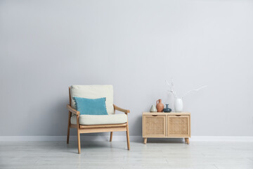 Comfortable armchair and decor near light gray wall indoors