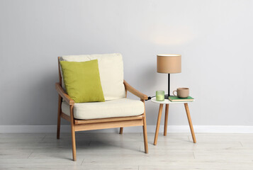 Comfortable armchair and decor near light gray wall indoors