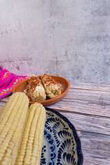 Cooked corn on the cob in a traditional Talavera dish on a wooden table