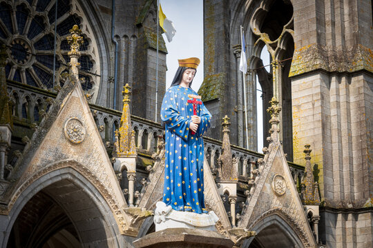 Sculpture of the crowned Virgin Mary standing on a pillar outside the Basilica of Pontmain in France