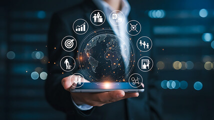 Businessman holding a smartphone displaying a futuristic digital interface with interconnected business icons and a glowing globe