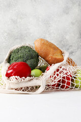 Fresh Groceries in Mesh Bag on Light Background