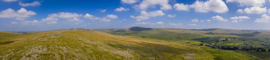 Rocky granite outcrops of Great Staple Tor in Dartmoor National Park under clear blue sky on a bright sunny day in summer