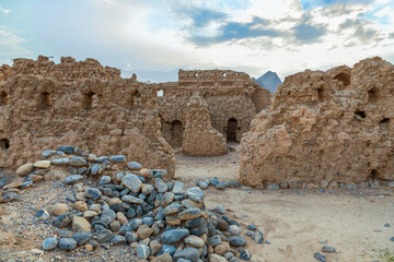 A view of the historic ruins of Old Tanuf village in Nizwa, Oman. The abandoned settlement is surrounded by mountains and built in traditional Omani architectural style, Sultanate of Oman . 