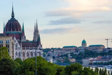 Fototapeta premium Scenic view of Budapest’s historic city center and iconic Parliament building, captured from Margaret Bridge over the Danube River.