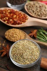 Different aromatic spices on wooden table, closeup
