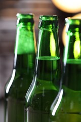 Bottles of beer on blurred grey background, macro view