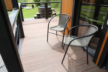 Rattan chairs on outdoor terrace at luxury resort in mountains