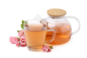 Tasty rose tea in glass cup, teapot and flowers isolated on white