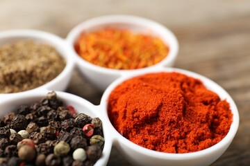 Different aromatic spices in bowls on table, closeup