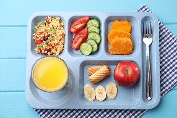 Plastic tray with tasty food, orange juice and fork on light blue wooden table, top view. School lunch