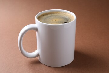 Tasty coffee in cup on brown table, closeup