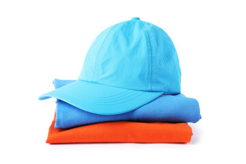Fototapeta premium Light blue baseball cap and stack of folded t-shirts isolated on white. Mockup for design