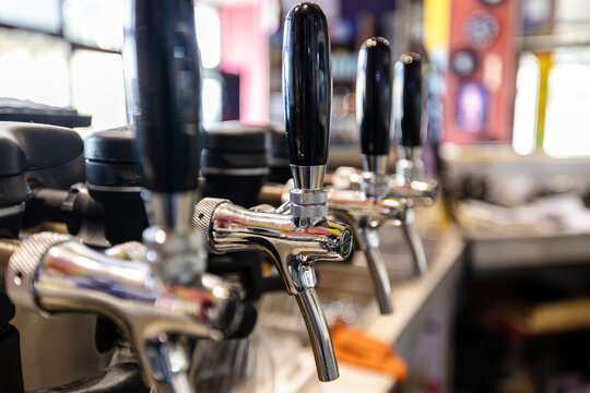 Close-up of beer taps at microbrewery. Details of the beer bar. Beer taps in a row in perspective. Selective focus. - Powered by Adobe