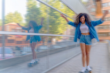 Young woman balancing with arms outstretched while skateboarding next to a modern glass wall in the...