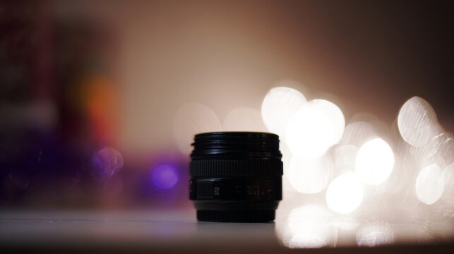 A digital photo of a magic wand and hat is isolated on a black background, with a bright lens flare highlighting the object