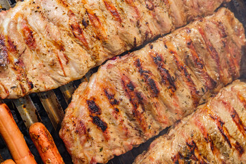 Sizzling Sausages and Ribs on a Hot Grill Grate. Concept The sounds and smells of summer.