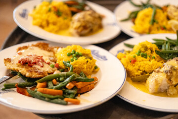 Colorful Plates of Spanish Cuisine with Chicken, Spanish Rice, Carrots, and Green Beans at Colombian Restaurant
